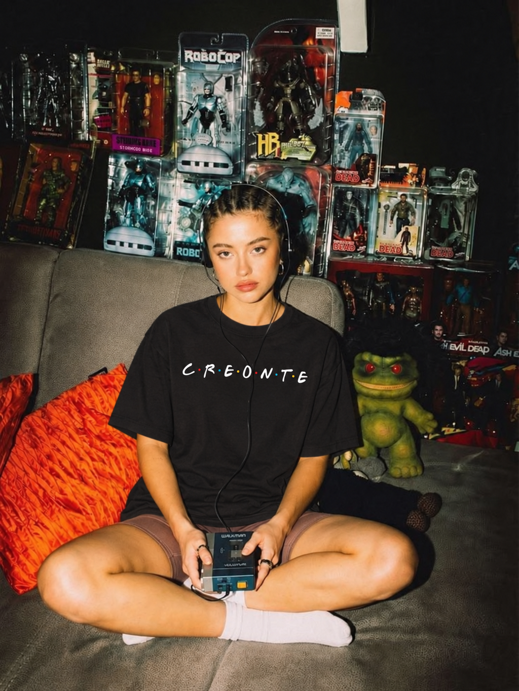 Black CREONTE oversized tee from BJJ World, script chest print worn seated on a couch.