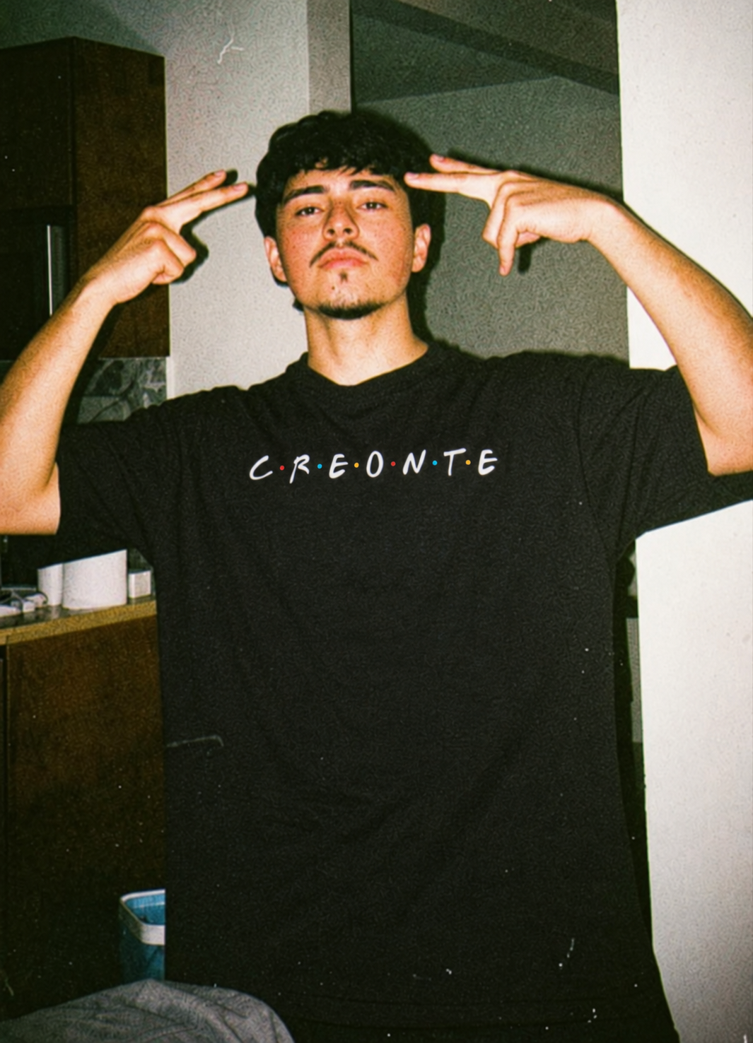 Black CREONTE tee from BJJ World, script chest print in a film-style indoor portrait.