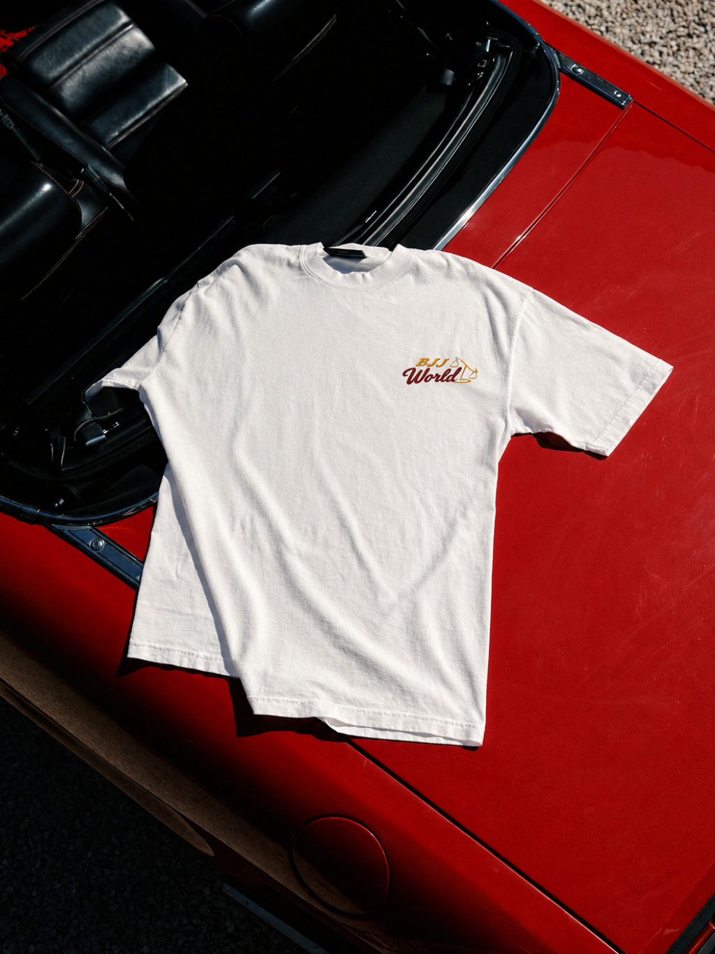 Cream Better Call Saul tee from BJJ World, folded on a red car showing the chest logo.
