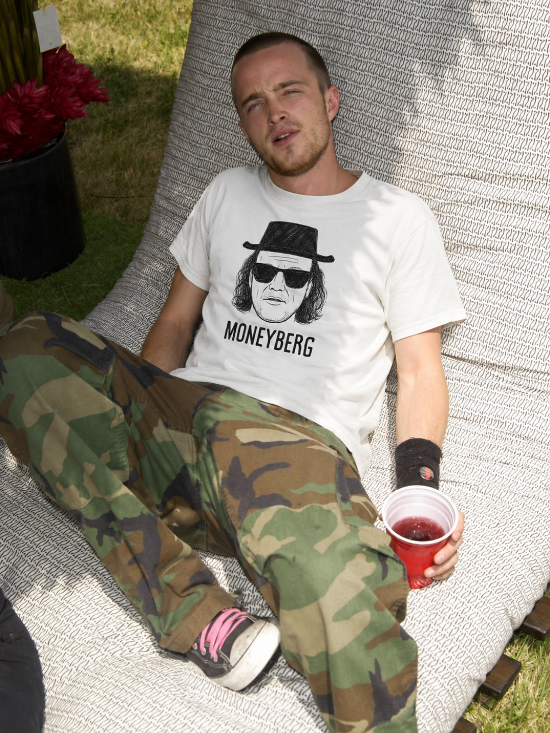 White Moneyberg tee from BJJ World, worn reclining outdoors.
